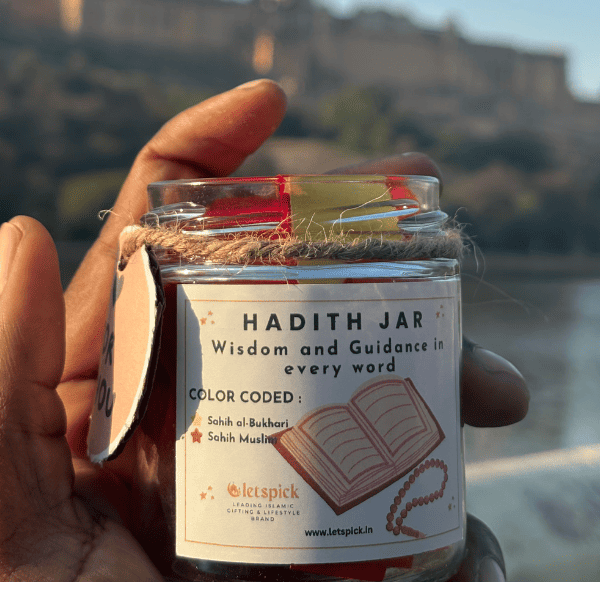Hand holding a 'Hadith Jar' with a scenic background of a fort.
